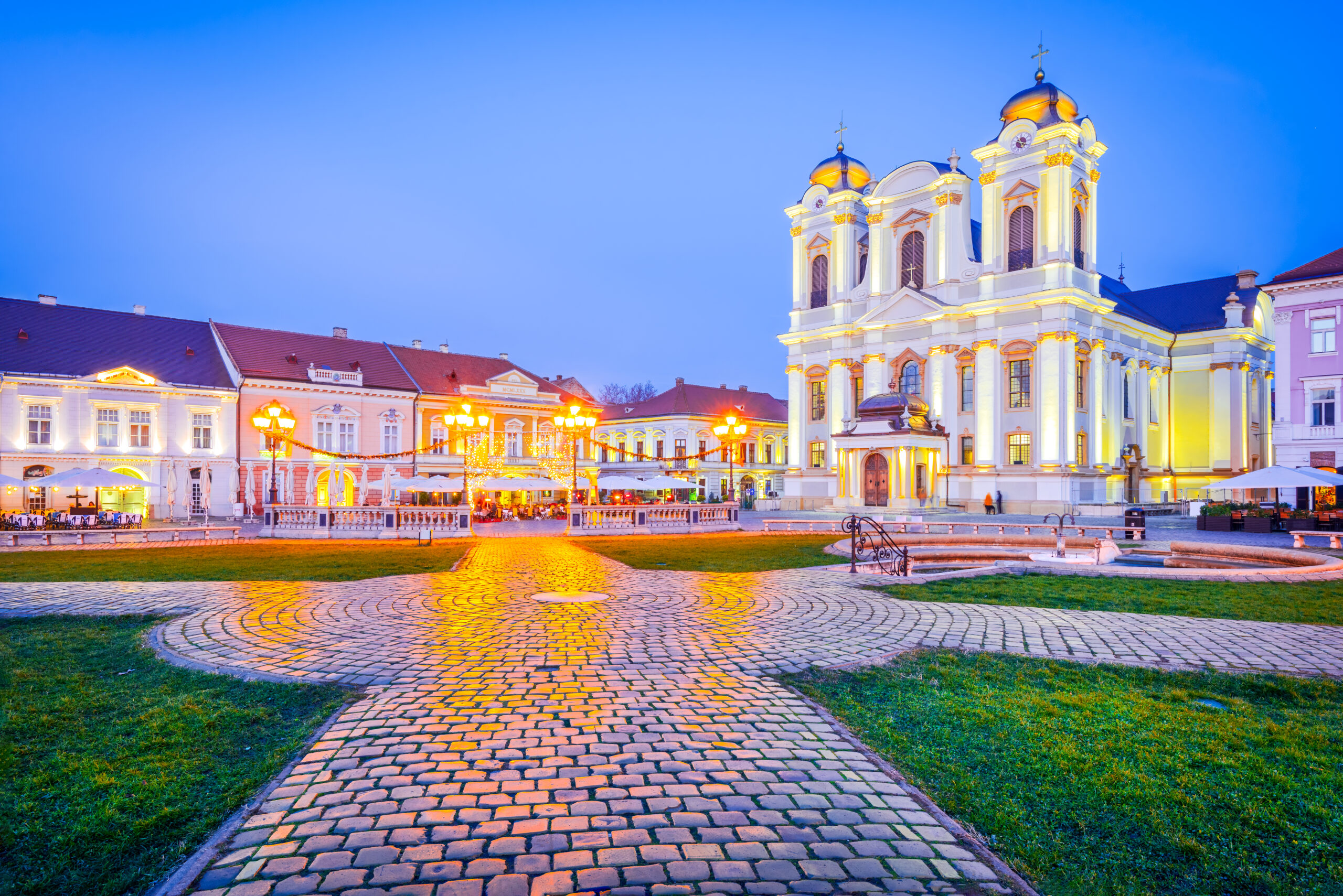 Timisoara, Banat - Romania. Night scene with Union Square downtown, beautiful baroque Catholic Cathedral.